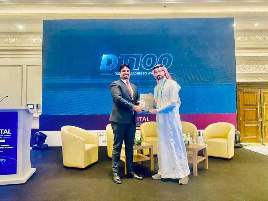Ahmed Ali Larik receiving the DT100 recognition on stage